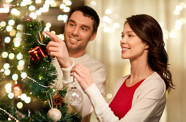 Image showing happy couple decorating christmas tree at home