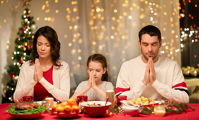 Image showing family praying before meal at christmas dinner