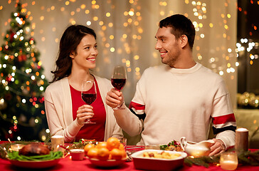 Image showing happy couple drinking red wine at christmas dinner