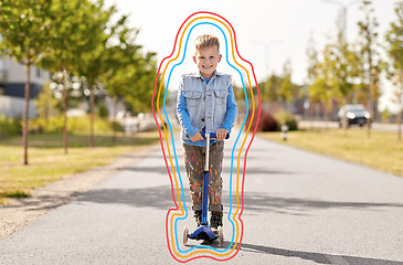 Image showing happy little boy riding scooter in city