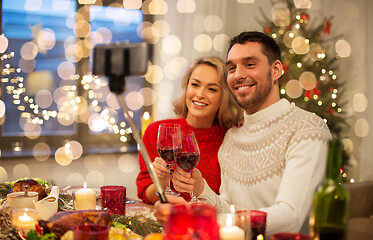 Image showing couple taking picture by selfie stick at christmas