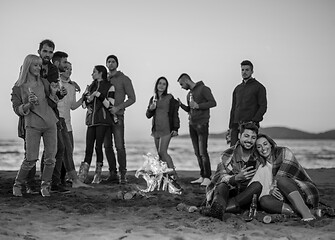 Image showing Couple enjoying bonfire with friends on beach