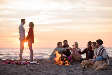 Image showing Couple enjoying with friends at sunset on the beach