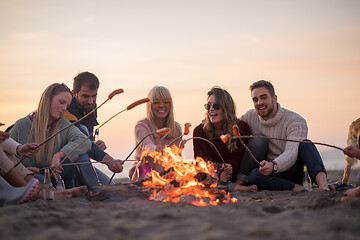 Image showing Group Of Young Friends Sitting By The Fire at beach