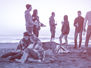 Image showing Couple enjoying with friends at sunset on the beach