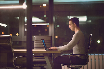 Image showing man working on laptop in dark office