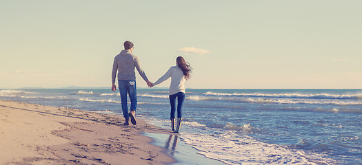 Image showing Loving young couple on a beach at autumn sunny day