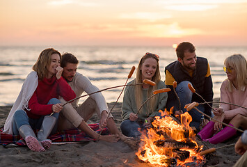 Image showing Group Of Young Friends Sitting By The Fire at beach