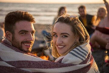 Image showing Couple enjoying with friends at sunset on the beach