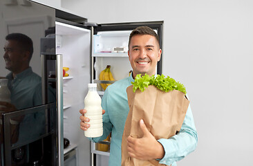 Image showing man with new purchased food at home fridge