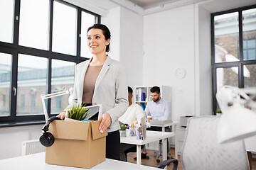 Image showing happy businesswoman with personal stuff at office