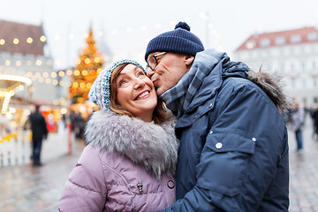 Image showing happy senior couple kissing at christmas market