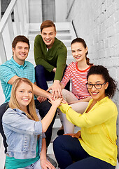 Image showing teenage friends or students stacking hands