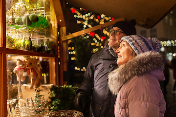 Image showing happy senior couple hugging at christmas market