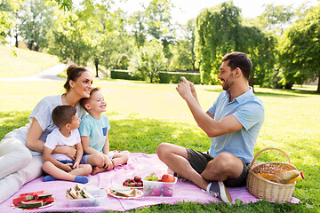 Image showing father taking picture of family on picnic at park