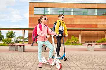 Image showing happy school children with backpacks and scooters