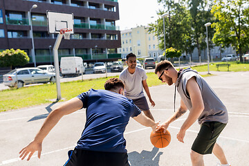 Image showing group of male friends playing street basketball