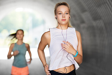 Image showing women or female friends with earphones running