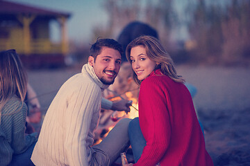 Image showing Couple enjoying with friends at sunset on the beach