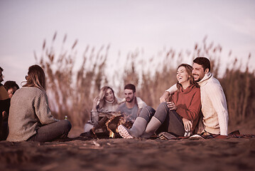 Image showing Couple enjoying with friends at sunset on the beach