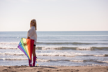 Image showing Young Woman with kite at beach on autumn day