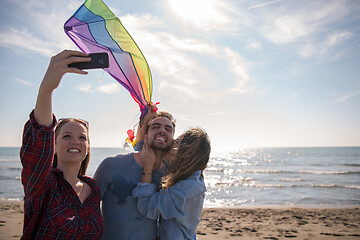 Image showing Group of friends making selfie on beach during autumn day