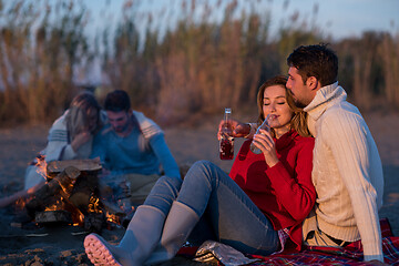 Image showing Couple enjoying with friends at sunset on the beach