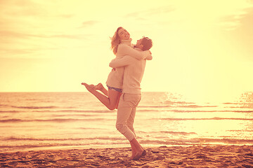 Image showing Loving young couple on a beach at autumn sunny day