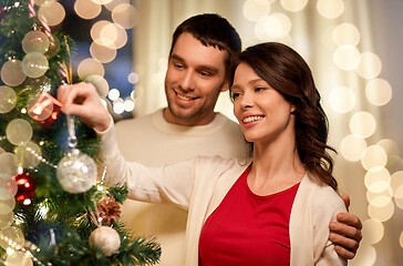 Image showing happy couple decorating christmas tree at home