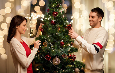 Image showing happy couple decorating christmas tree at home