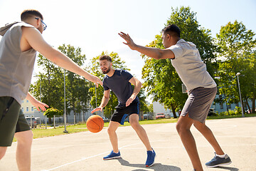 Image showing group of male friends playing street basketball