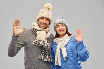 Image showing happy couple in winter clothes waving hands
