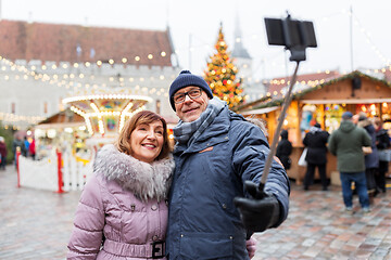 Image showing senior couple taking selfie at christmas market