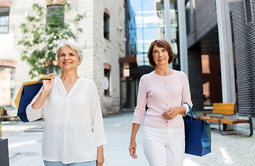 Image showing senior women with shopping bags walking in city