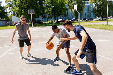 Image showing group of male friends playing street basketball