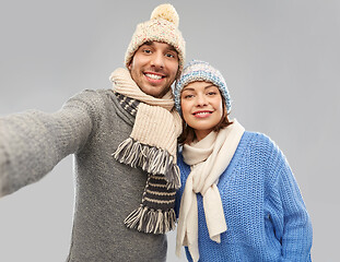 Image showing happy couple in winter clothes taking selfie