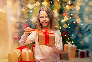 Image showing smiling girl with christmas gift at home