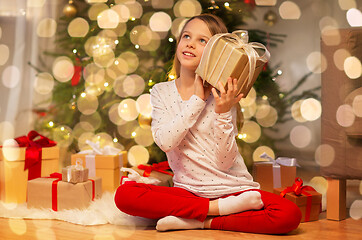 Image showing smiling girl with christmas gift at home