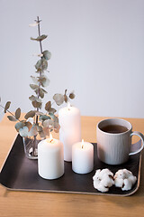 Image showing candles, tea and branches of eucalyptus on table