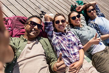 Image showing friends or tourists with backpacks taking selfie