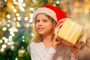 Image showing smiling girl in santa hat with christmas gift