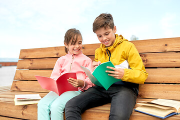 Image showing school children with notebooks sitting on bench