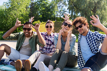 Image showing happy friends making faces at summer park