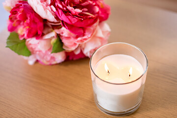 Image showing burning fragrance candle and flower bunch on table