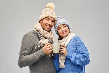 Image showing happy couple in winter clothes with mugs