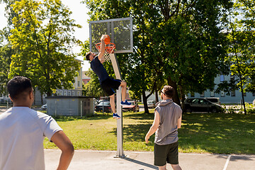 Image showing group of male friends playing street basketball