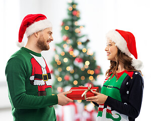 Image showing happy couple in sweaters with christmas gift