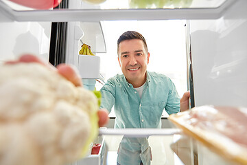 Image showing man taking vegetable from fridge at home kitchen