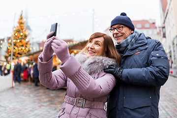 Image showing senior couple taking selfie at christmas market