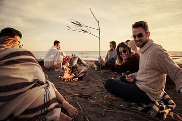 Image showing Couple enjoying with friends at sunset on the beach